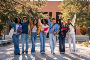 Group,Of,Young,,Happy,,Diverse,University,Students,Standing,Together,,Raising Group,Of,Young,,Happy,,Diverse,University,Students,Standing,Together,,Raising